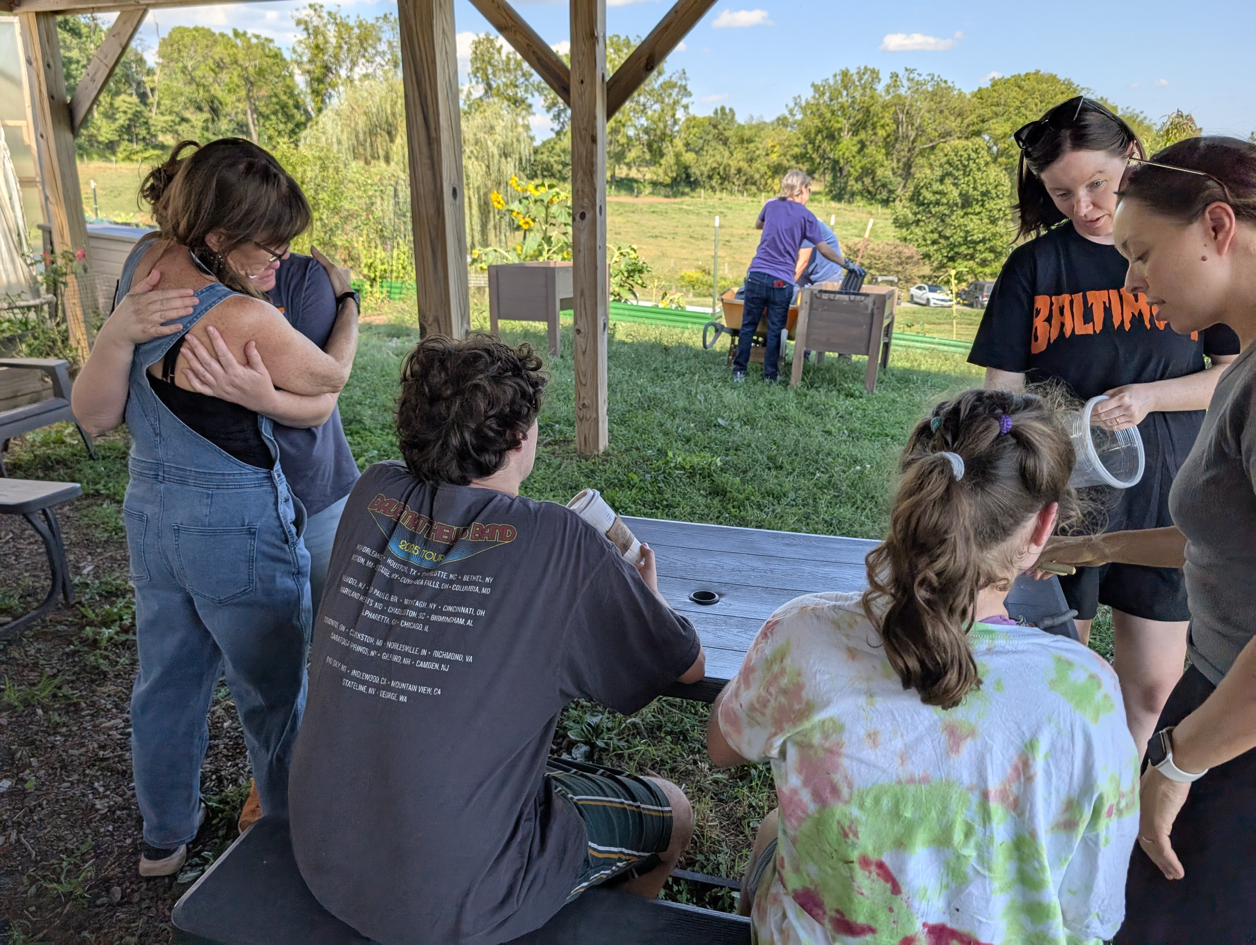 Group under a pavilion at the farm interacting together